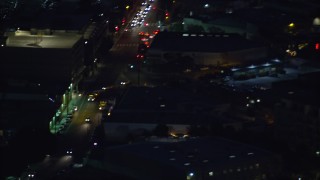 AX0158_099 - 7.6K aerial stock footage of an LAPD helicopter flying over Downtown Los Angeles, California at night