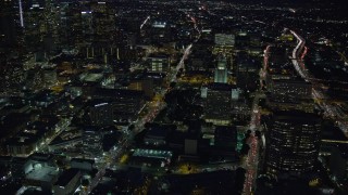 AX0158_102E - 7.6K aerial stock footage flying by City Hall and approach LAPD headquarters at night in Downtown Los Angeles, California