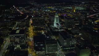 AX0158_106E - 7.6K aerial stock footage orbiting LA City Hall to reveal skyscrapers at night in Downtown Los Angeles, California