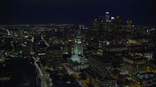 AX0158_108 - 7.6K stock footage aerial video orbiting LA City Hall to reveal skyscrapers at night in Downtown Los Angeles, California
