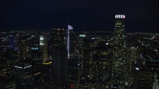 AX0158_111E - 7.6K aerial stock footage of Aon Center to reveal Wilshire Grand Center at night, Downtown Los Angeles, California
