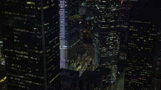 AX0158_117E - 7.6K aerial stock footage of a view of the base of Wilshire Grand Center at night in Downtown Los Angeles, California