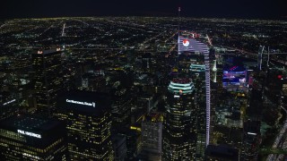 AX0158_121E - 7.6K aerial stock footage orbiting and tilt to a bird's eye of Wilshire Grand Center in Downtown Los Angeles, California at night