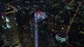 AX0158_122 - 7.6K stock footage aerial video orbiting and tilt to a bird's eye of Wilshire Grand Center in Downtown Los Angeles, California at night