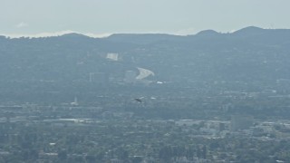 AX0159_003 - 7.6K aerial stock footage tracking a Cessna flying over San Fernando Valley, cloudy, California
