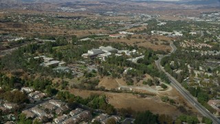 AX0159_023 - 7.6K aerial stock footage of a wide shot of California Institute of the Arts nestled among suburban neighborhoods, Santa Clarita, California