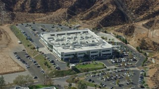 AX0159_038E - 7.6K aerial stock footage orbiting a tech office building and parking lot, Valencia, California