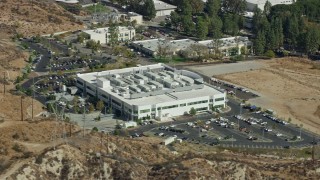 AX0159_040E - 7.6K aerial stock footage passing by front of tech office building, Valencia, California