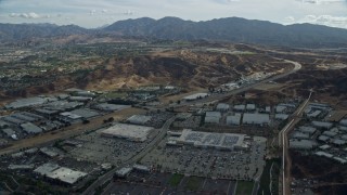 AX0159_048E - 7.6K aerial stock footage of a road and warehouses, Santa Clarita, California