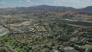 AX0159_050E - 7.6K aerial stock footage of suburban housing and an interchange with mountains in the distance, Santa Clarita, California