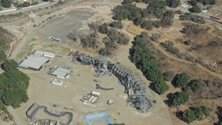 AX0159_054 - 7.6K aerial stock footage orbiting away form old Wipe Out set and a dinosaur structure at Sable Ranch, Santa Clarita, California