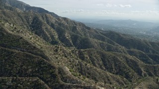 AX0159_060E - 7.6K aerial stock footage flying over mountain ridges, La Crescenta, California