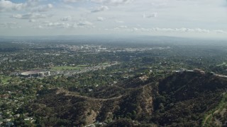 AX0159_092 - 7.6K aerial stock footage flying over hilltop toward residential neighborhoods below, Pasadena, California