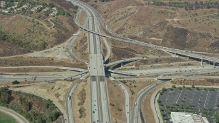 AX0159_133 - 7.6K stock footage aerial video of a reverse view of the I-10 / Hwy 57 / Hwy 71 Interchange in Pamona, California