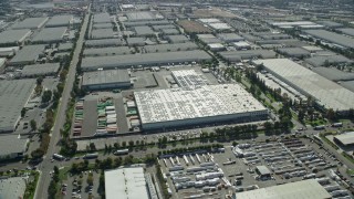 AX0159_138 - 7.6K stock footage aerial video flying over large warehouses in Chino, California