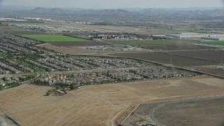 AX0159_139E - 7.6K aerial stock footage flying over tract homes towards the East Yard of CIM Prison (California Institution for Men), Chino, California