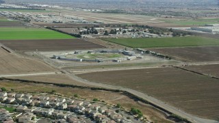 AX0159_140 - 7.6K stock footage aerial video flying over tract homes towards East yard CIM Prison (California Institution for Men) in Chino, California