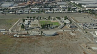 AX0159_142 - 7.6K aerial stock footage approaching the California Institution for Men prison in Chino, California
