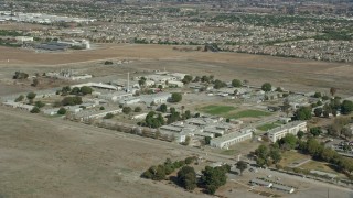 AX0159_144E - 7.6K aerial stock footage orbiting California Institution for Men buildings in Chino, California