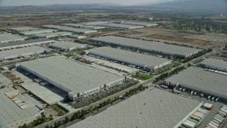 AX0159_151 - 7.6K stock footage aerial video of several large warehouse buildings in Chino, California