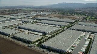 AX0159_151E - 7.6K aerial stock footage of several warehouses in Chino, California