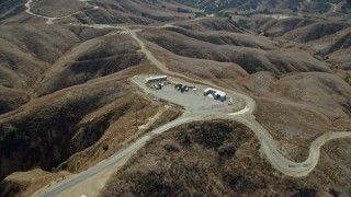 AX0159_154 - 7.6K stock footage aerial video flying over storage facility in the hills near dirt trails, Chino Hills State Park, California