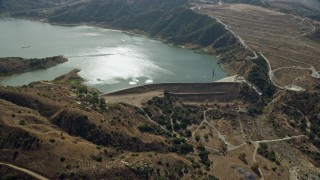 AX0159_161 - 7.6K stock footage aerial video approaching and tilt down on dam and lake, Irvine Lake, Orange, California