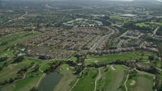 AX0159_177 - 7.6K stock footage aerial video flying over golf course and tract homes, Aliso Viejo, California