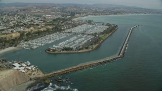 AX0159_192E - 7.6K aerial stock footage flying over boats at Dana Point Harbor, and approach the shore in Dana Point, California