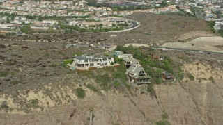 AX0159_199 - 7.6K aerial stock footage of clifftop mansions and Dana Point Nature Interpretive Center in Dana Point, California