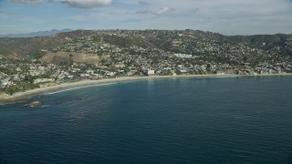 AX0159_212E - 7.6K aerial stock footage flying away from beach and over coastal community, Laguna Beach, California
