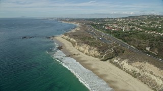 AX0159_228 - 7.6K stock footage aerial video flying over beach along coastal highway, Newport Beach, California