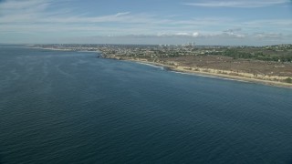AX0159_231E - 7.6K aerial stock footage flying along coast over blue ocean waters toward Pelican Point, Newport Beach, California