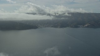AX0159_246 - 7.6K aerial stock footage of low clouds over the island town of Avalon, Catalina Island, California