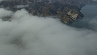 AX0159_250E - 7.6K aerial stock footage flying over clouds to reveal Avalon, Catalina Island, California