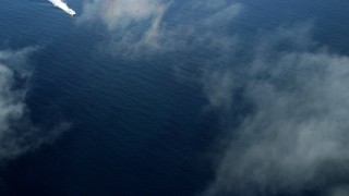 AX0160_030 - 7.6K stock footage aerial video flying over clouds over open water to reveal a ferry off the coast of Southern California