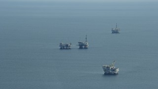 AX0160_033 - 7.6K aerial stock footage of oceanic oil rigs off the coast of Southern California