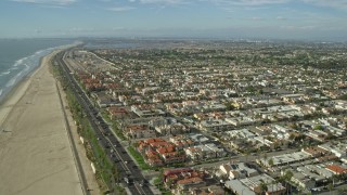 AX0160_043 - 7.6K aerial stock footage flying over the beach, Highway 1, and the oceanfront city of Huntington Beach, California