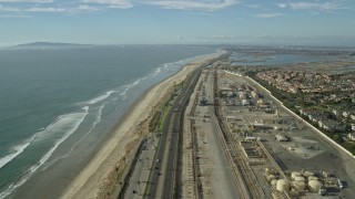 AX0160_044E - 7.6K aerial stock footage of homes around an industrial area next to the beach and Hwy 1, Huntington Beach, California