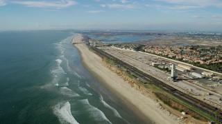 AX0160_045 - 7.6K stock footage aerial video of Hwy 1 between an industrial area and the beach, Huntington Beach, California