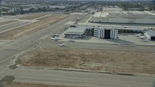 AX0160_067 - 7.6K stock footage aerial video of a jet making its way to the runway at Long Beach Airport, California