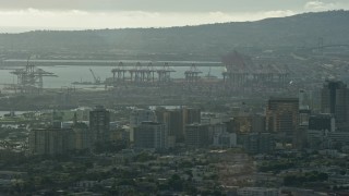 AX0161_003 - 7.6K stock footage aerial video of cargo cranes at the port and office buildings in Downtown Long Beach, California