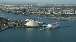 AX0161_008 - 7.6K stock footage aerial video of a cruise ship and Queen Mary docked near Downtown Long Beach, California