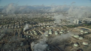 AX0161_042E - 7.6K aerial stock footage flying over low level clouds to reveal the Chevron oil refinery in El Segundo, California