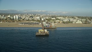 AX0161_078E - 7.6K aerial stock footage flying by the end of Santa Monica Pier in Santa Monica, California
