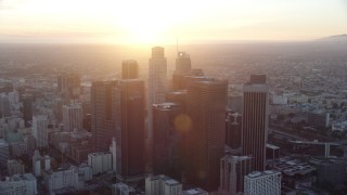 AX0162_085 - 7.6K stock footage aerial video of a reverse view of the tall towers of downtown at sunset in Downtown Los Angeles, California