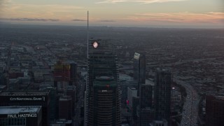 AX0162_090 - 7.6K aerial stock footage of tops of Wilshire Grand Center and US Bank Tower at sunset in Downtown Los Angeles, California