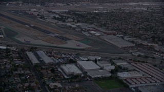 AX0162_115 - 7.6K aerial stock footage of commercial airplanes on the end of the runway at Burbank Airport, California, twilight