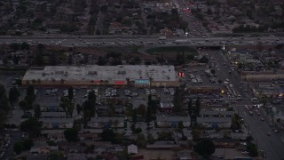 AX0162_120 - 7.6K aerial stock footage of Pacoima Center shopping center in Pacoima, California at twilight