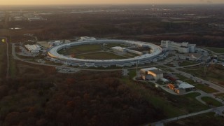 AX0163_0008 - 4K aerial stock footage of flying by the Advanced Photon Source at the Argonne National Laboratory at sunset in Lemont, Illinois
